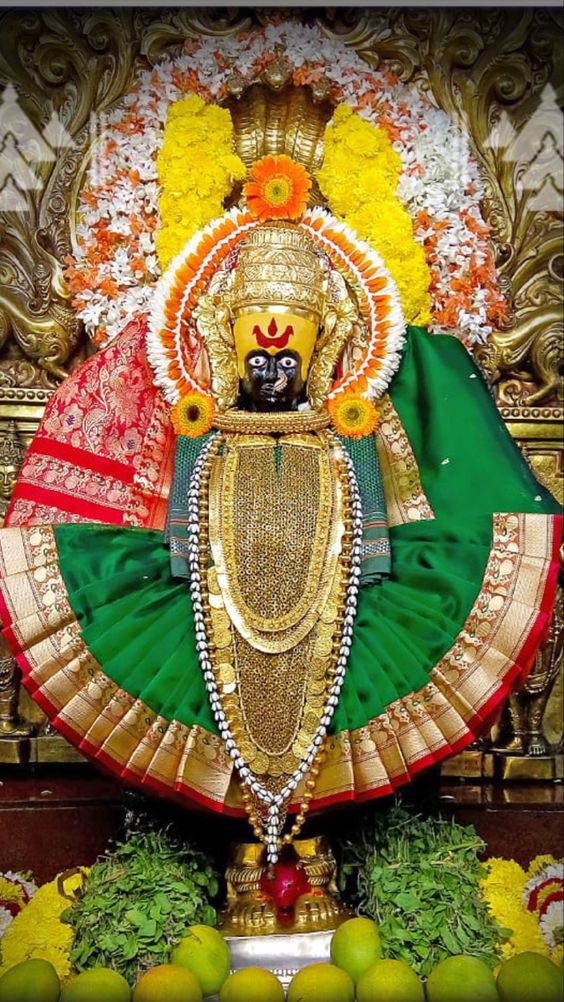 Mahalakshmi Ambabai adorned with flowers, gold ornaments and a green silk saree